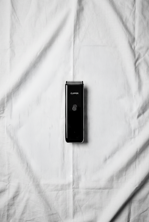 Black hair clipper on a white fabric background